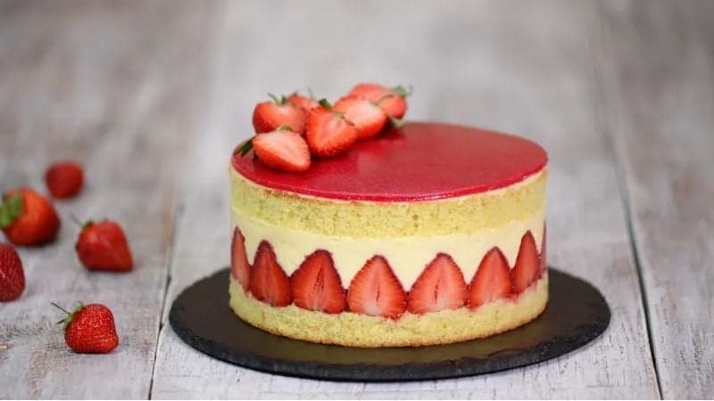 Un Fraisier Vegan sur une planche en granite pour une découpe propre