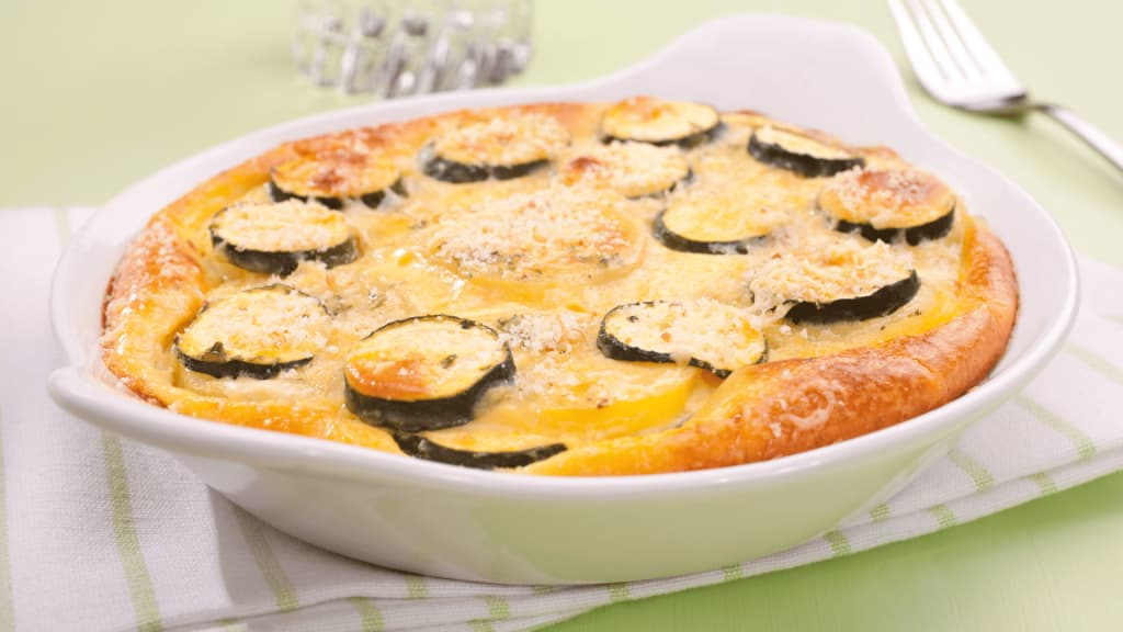 Couches de courgettes et pommes de terre montées dans un plat à gratin
