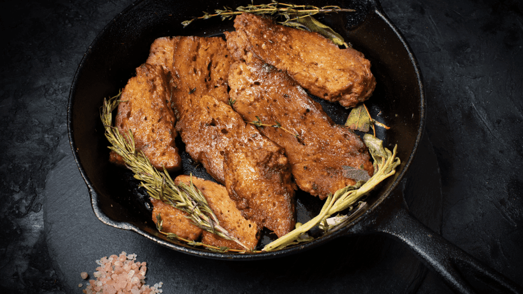 Le meilleur seitan avec des herbes aromatiques en train de cuire dans une poêle bien chaude
