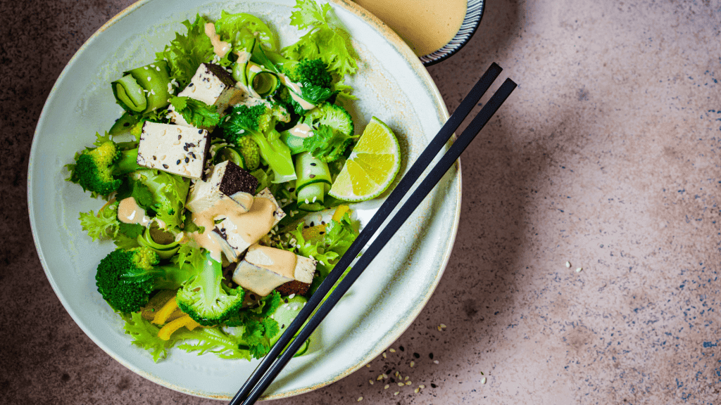 Une salade avec le meilleur tofu fumé, des concombres, des brocolis et du citron vert