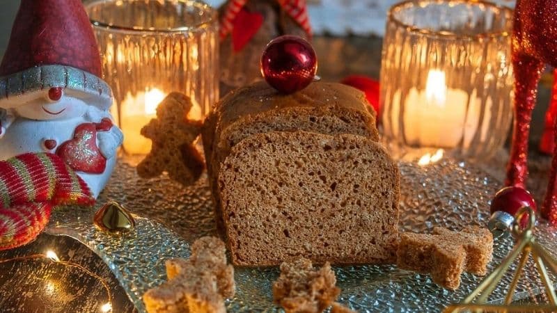 Un Pain d'épices Vegan posé sur une table en verre avec une décoration de Noel