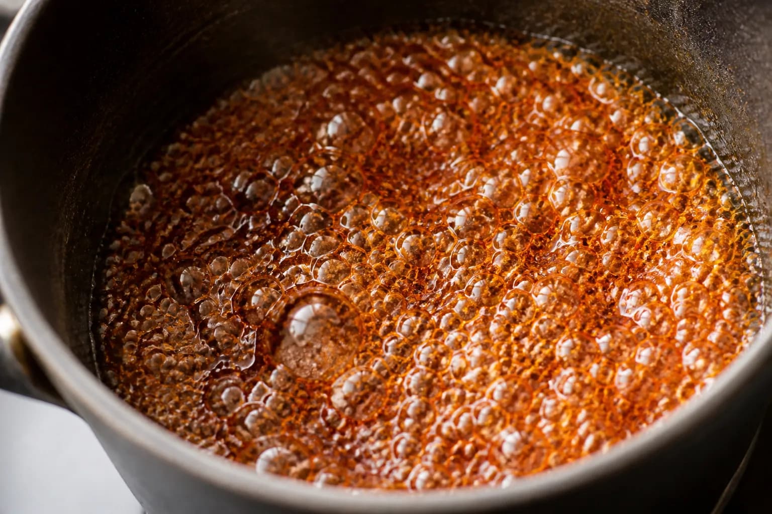 Sucre de canne en train de caraméliser à sec dans une casserole jusqu'à une couleur ambrée