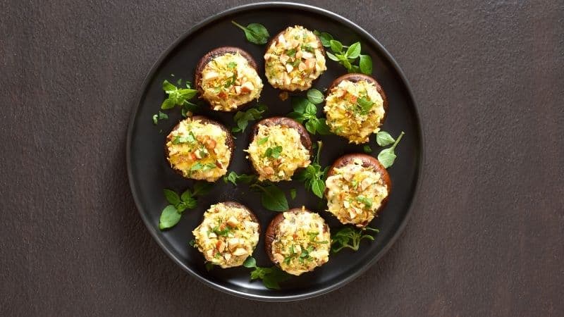 Des champignons farcis vegan avec des noix concassées en toping pour une texture croquante