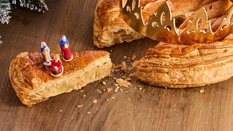 Une galette des rois avec une couronnes et des fèves avec de la frangipane vegan
