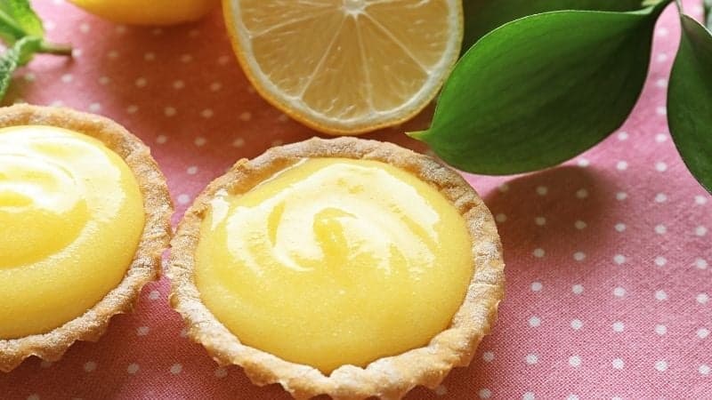 Une tarte au citron avec du Lemon Curd Vegan sur une nappe rose