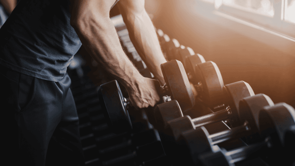 Un homme qui replace ses poids à la salle de sport après avoir fini ses répétitions