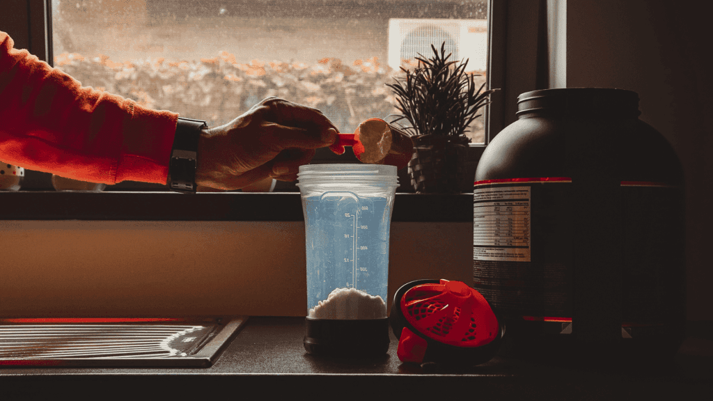 Un homme qui verse une dose de la meilleure protéine vegan dans un shaker avant sa séance de sport