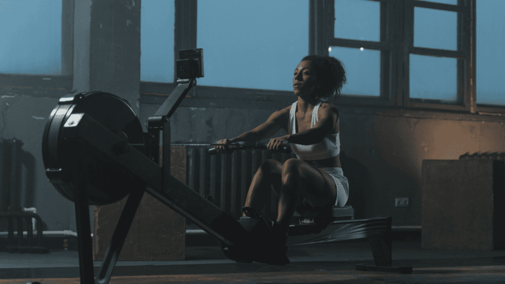 Une femme faisant une séance de cardio dans une salle de sport le soir