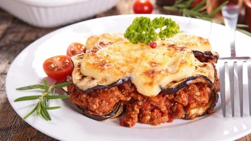 Une moussaka vegan servi à l'assiette avec une belle sauce tomate et des aubergines bien cuites
