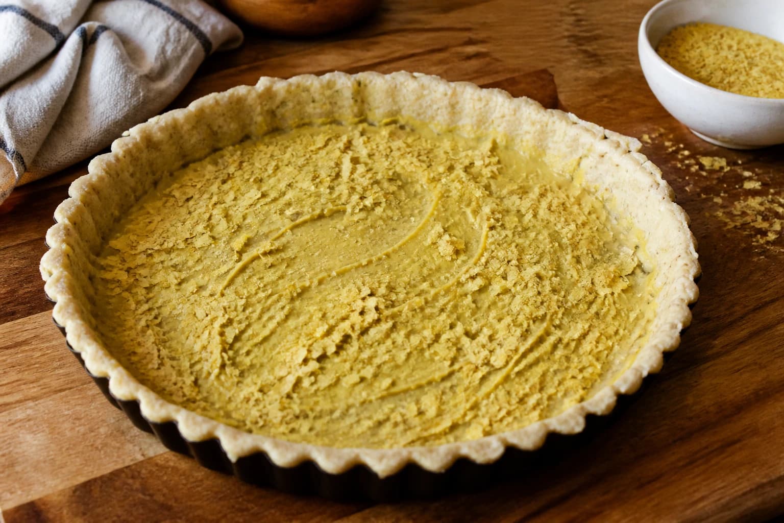 Fond de tarte précuit recouvert de moutarde de Dijon et saupoudré de levure maltée
