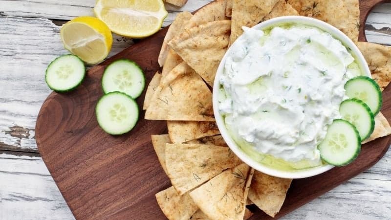 Un Tzatziki Vegan sur un plateau en bois avec des nachos pour le déguster
